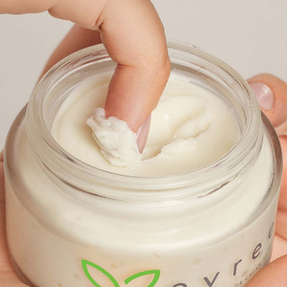 Fingertip scooping a little evree massage cream from the jar